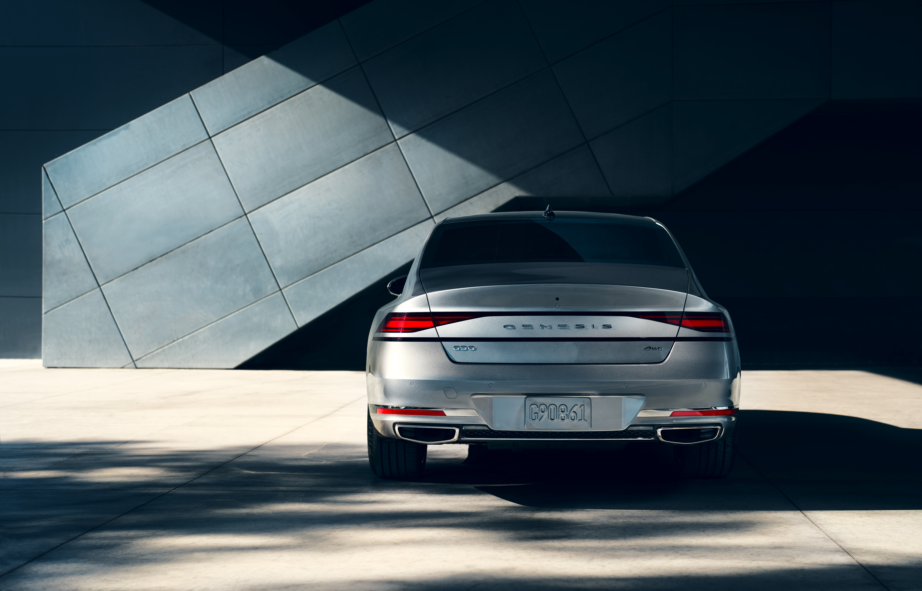 Trunk and rear tail lights of G90 parked in front of a building.