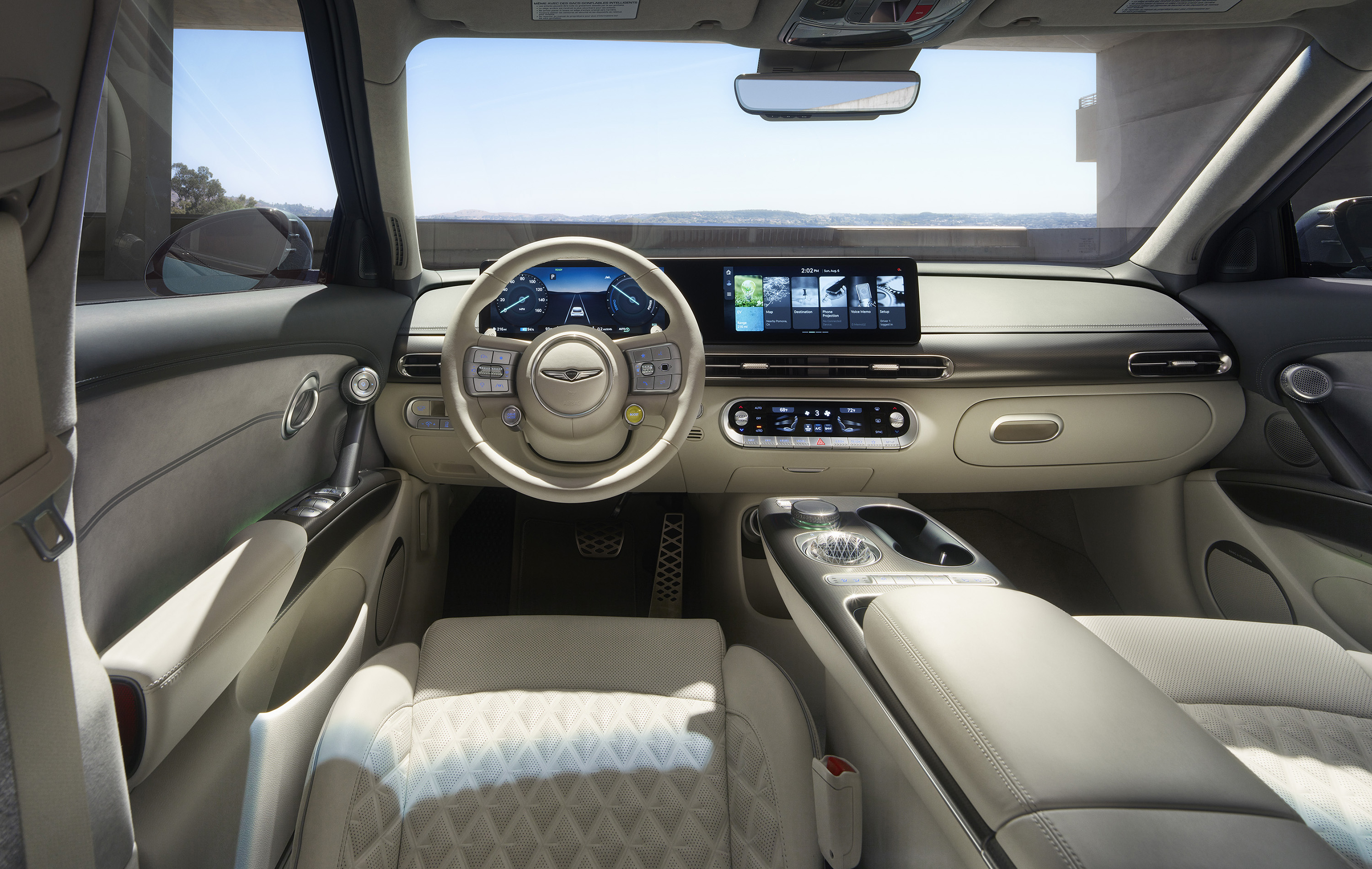 Driver's side interior view of the GV60 showcasing the infotainment console and steering wheel.